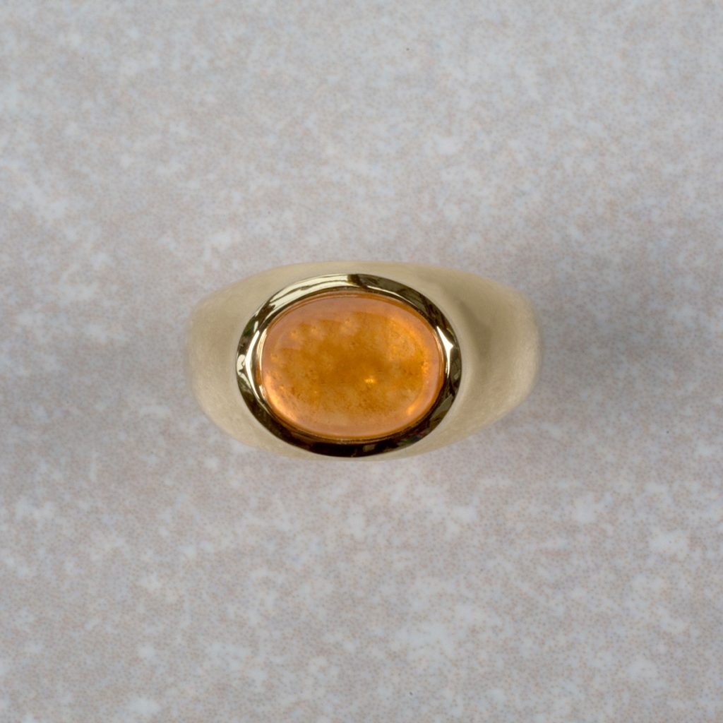 18 Carat Gold ring Set with an Oval Mandarin Garnet Cabochon.
