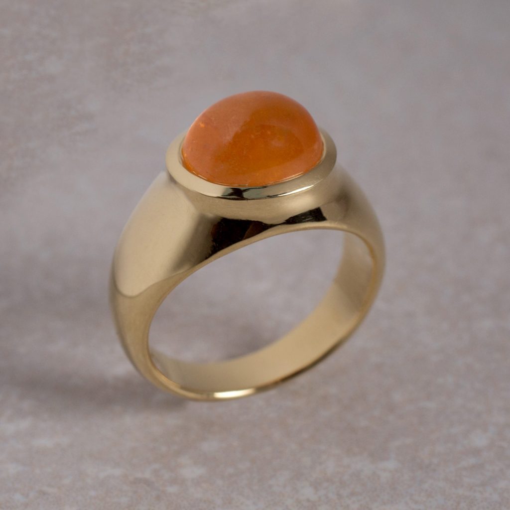 18 Carat Gold ring Set with an Oval Mandarin Garnet Cabochon.
